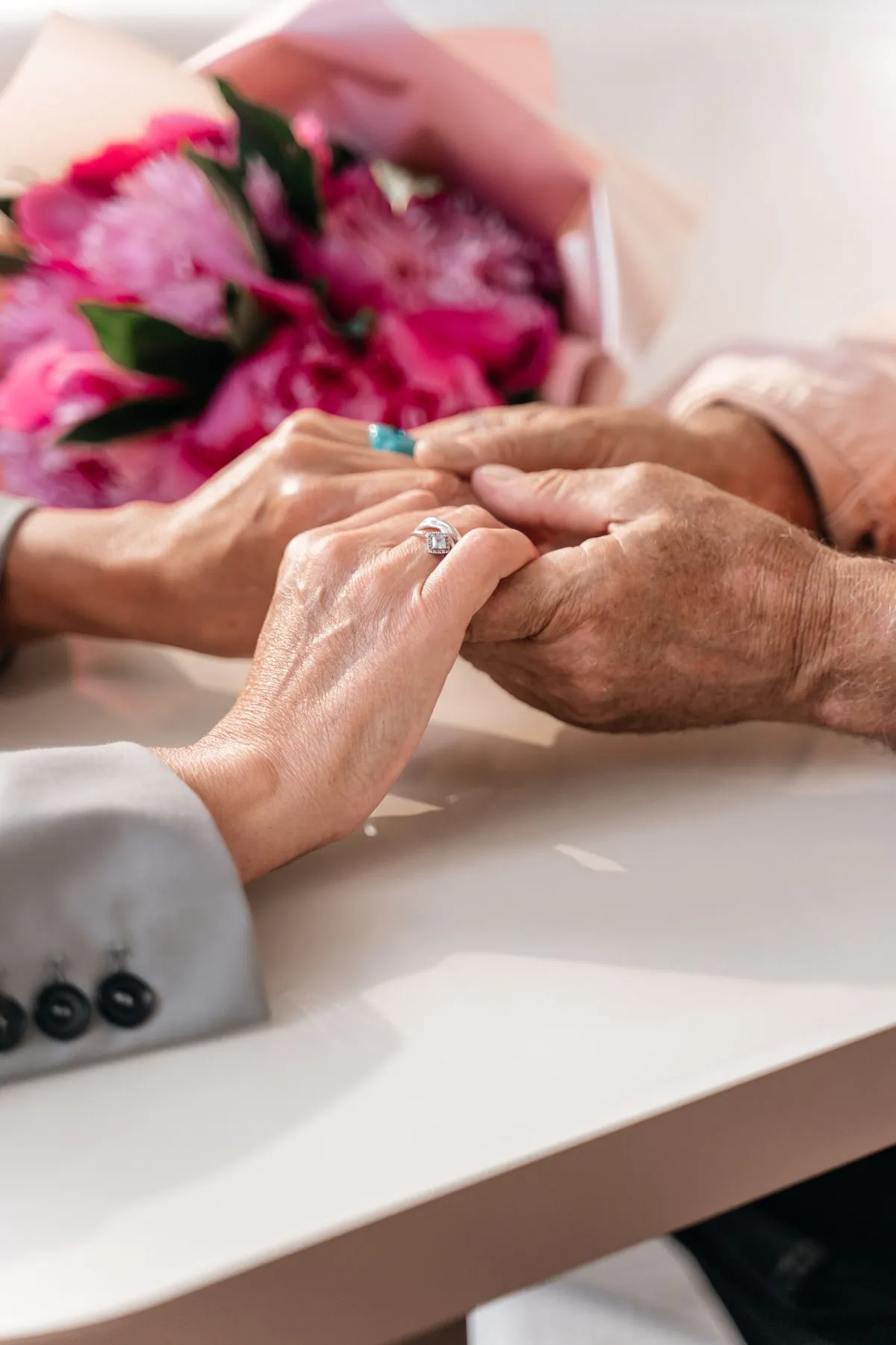 An older couple holding hands across a table